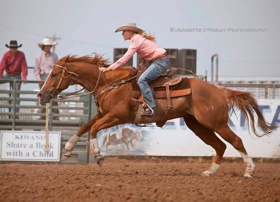 A woman riding a horse in full gallop