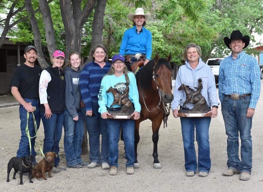 A large group of people next to a horse